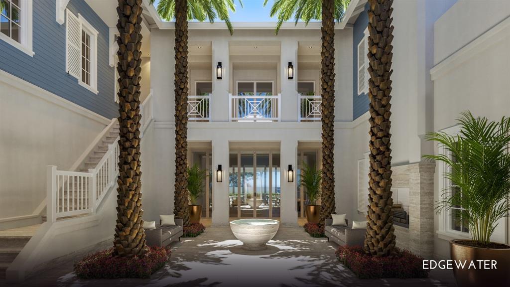 An aerial view of a blue two-story beachfront house with a metal roof at sunset — 1420/1440 GULF BOULEVARD, BELLEAIR SHORE, FL