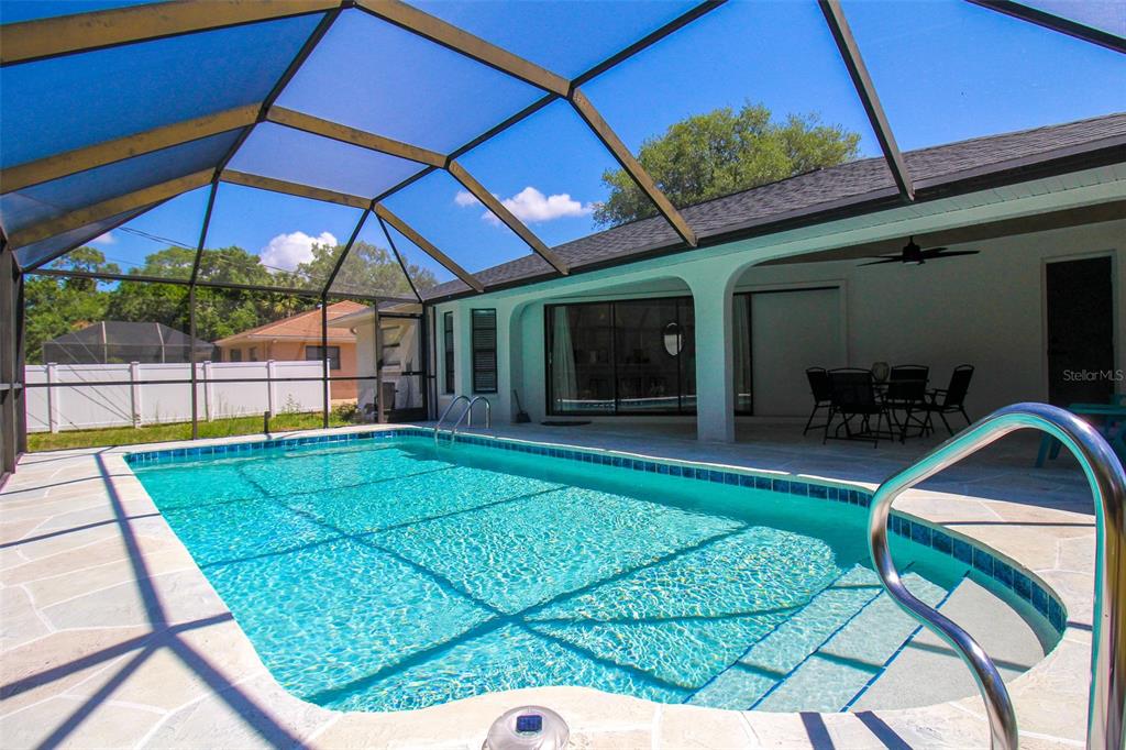 A screened-in swimming pool with a patio and outdoor dining area under a covered lanai — 4113 DURANT STREET, PORT CHARLOTTE, FL
