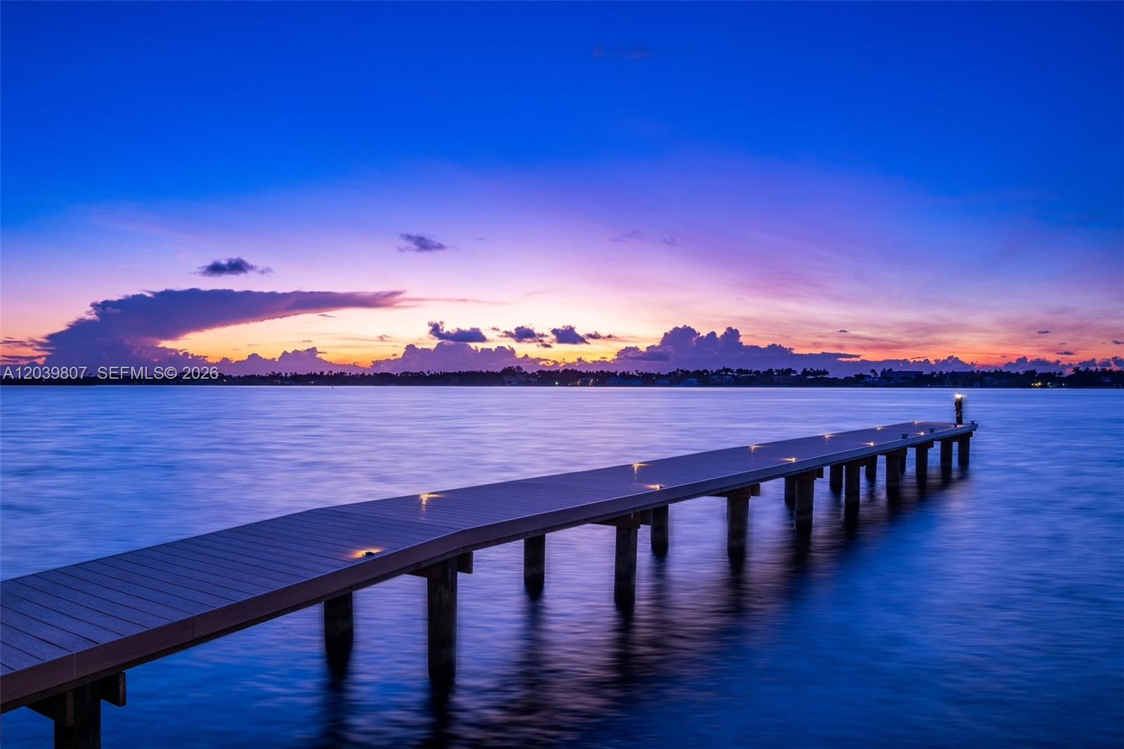 A wooden pier with integrated lights extends into a calm body of water at sunset — 6315 S Flagler Dr, West Palm Beach FL 33405, WEST PALM BEACH, FL