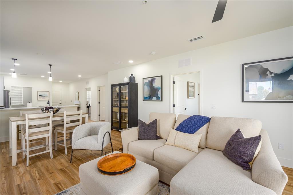 A living room features a beige sectional sofa, an ottoman, and an adjacent dining area — 419 SE 1ST AVENUE UNIT 103, OCALA, FL