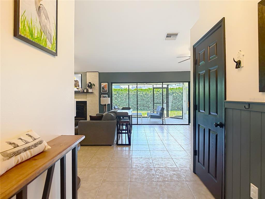 An entryway leads into a living room with tile floors, a fireplace, and a screened patio — 9902 STEPHENSON DRIVE, NEW PORT RICHEY, FL