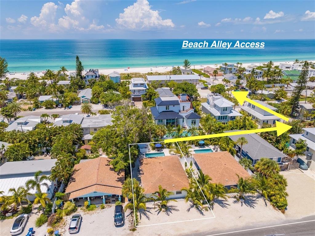 An aerial view shows beach houses with pools near the ocean and a beach access path — 3014 GULF DRIVE, HOLMES BEACH, FL