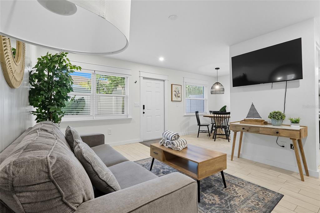 A living room features a gray sofa, a wooden coffee table, and a wall-mounted television — 3014 GULF DRIVE, HOLMES BEACH, FL