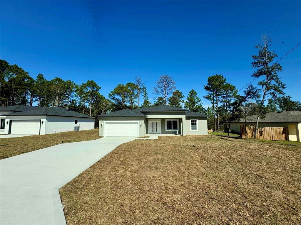 A newly constructed single-story house with a white garage and a concrete driveway — 2085 W HAMPSHIRE BOULEVARD, CITRUS SPRINGS, FL