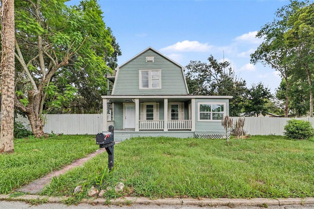 A two-story, light green house with a front porch and a black mailbox — 1515 INDIANA AVENUE, ST CLOUD, FL