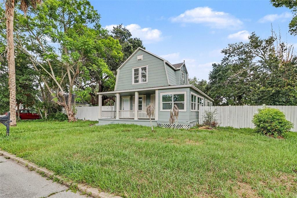 A two-story, light green house with a gambrel roof and a front porch — 1515 INDIANA AVENUE, ST CLOUD, FL