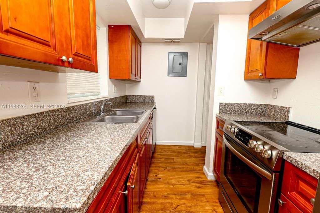 A kitchen features wood cabinets, granite countertops, and stainless steel appliances — 4103 Riverside Dr, Coral Springs FL 33065, CORAL SPRINGS, FL