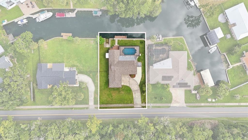 An aerial view shows a house with a pool and dock along a canal — 220 SE KINGS BAY DRIVE, CRYSTAL RIVER, FL