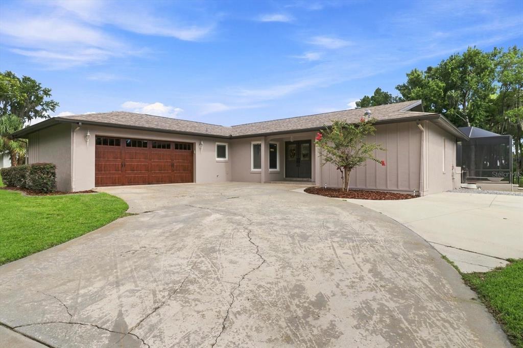 A single-story house with a brown garage door, a concrete driveway, and a front entrance — 220 SE KINGS BAY DRIVE, CRYSTAL RIVER, FL