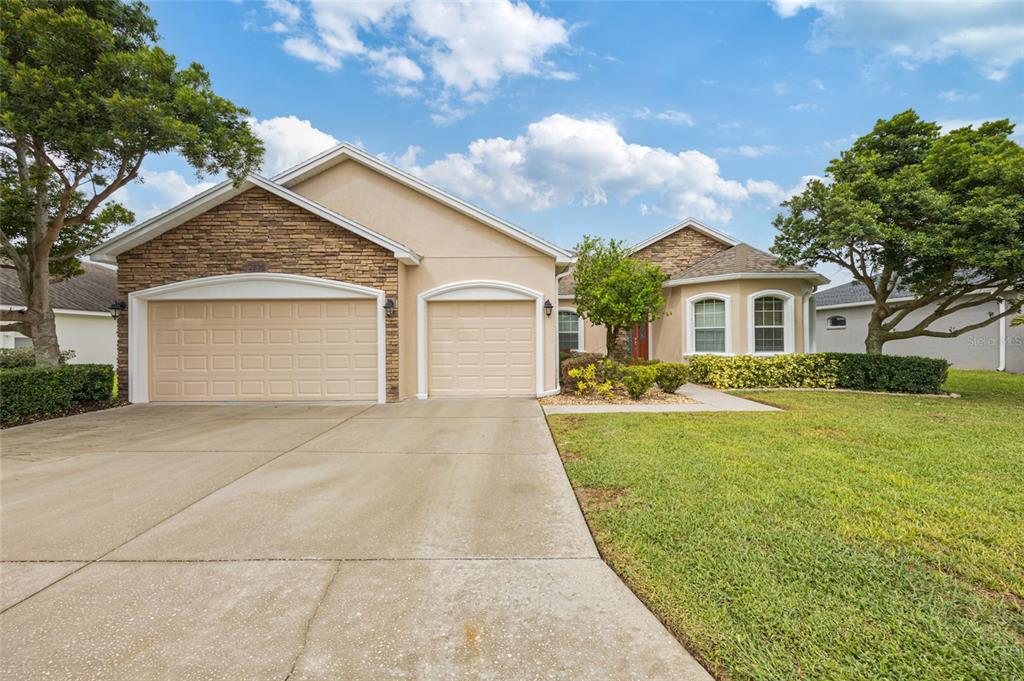 A single-story house with a two-car garage, stone accents, and a concrete driveway — 2836 WHITNEY STREET, LAKELAND, FL