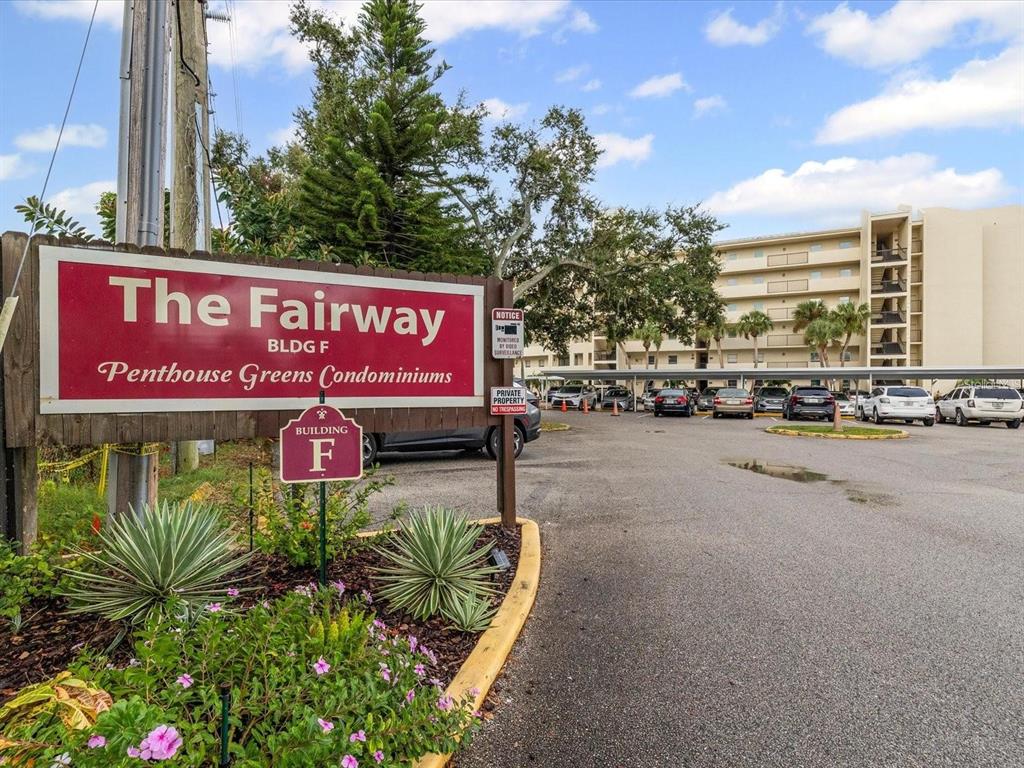 A sign for The Fairway at Penthouse Greens Condominiums stands before a parking lot — 225 COUNTRY CLUB DRIVE UNIT 1604, LARGO, FL