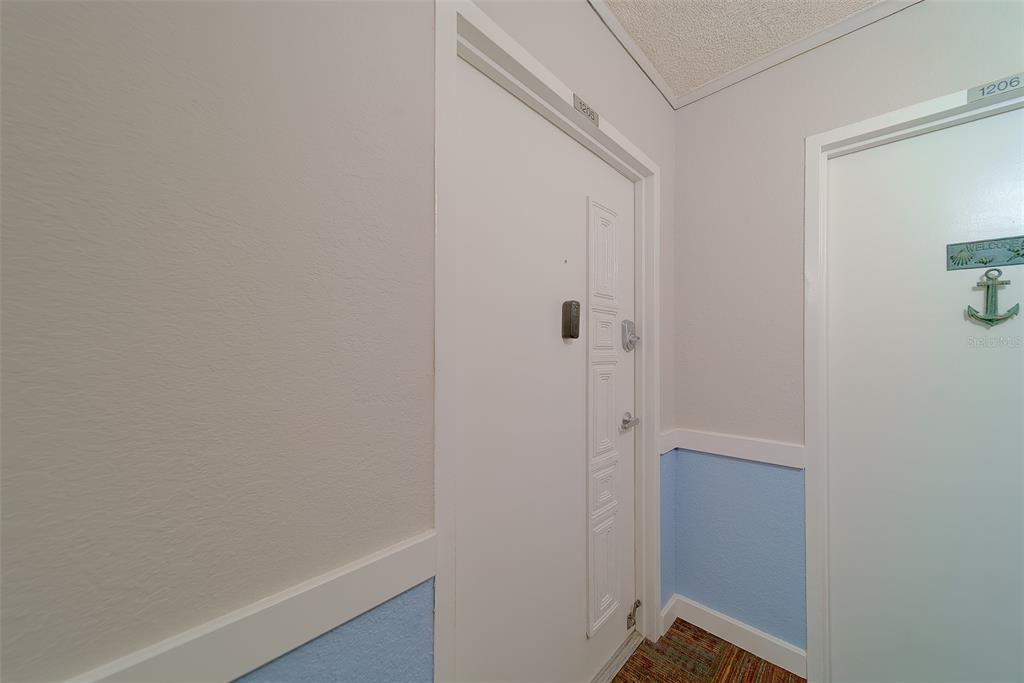 A hallway view showing two white apartment doors labeled 1205 and 1206 — 17920 GULF BOULEVARD UNIT 1205, REDINGTON SHORES, FL