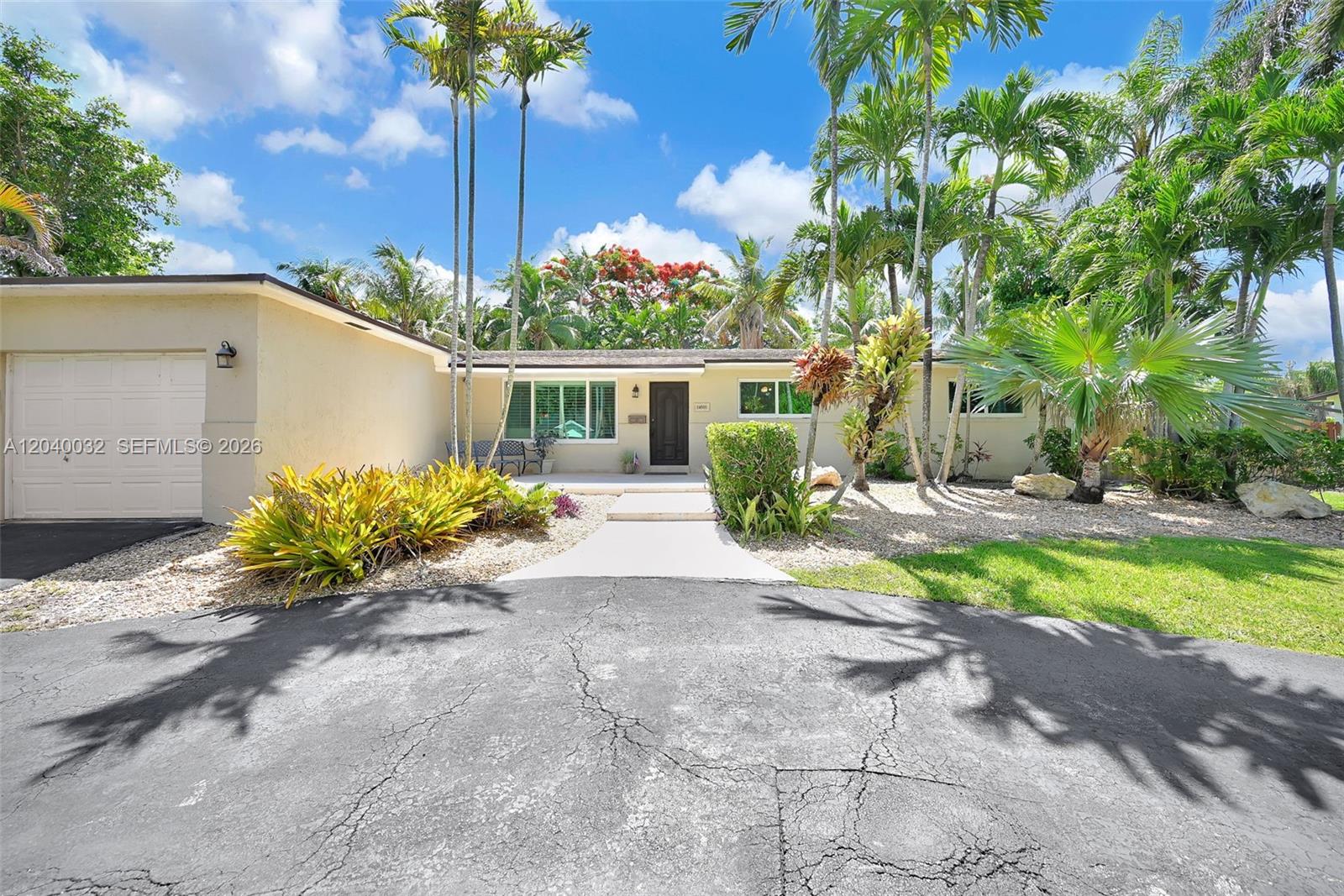 A single-story house with a beige exterior, a garage, and a palm-filled front yard — 14501 SW 99th Ave, Miami FL 33176, MIAMI, FL