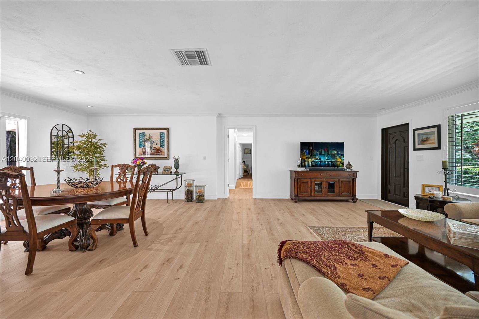 A dining and living area features light wood flooring, white walls, and a wooden console — 14501 SW 99th Ave, Miami FL 33176, MIAMI, FL
