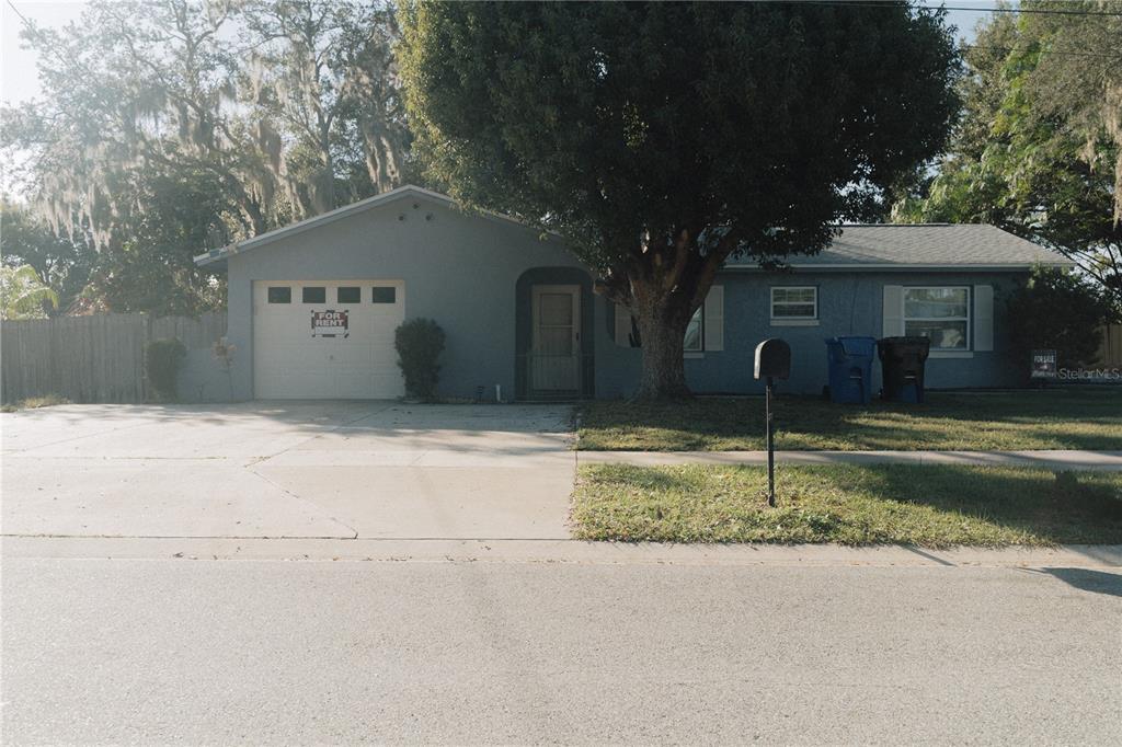 A single-story blue house with a garage and a large tree in the front yard — 503 APRICOT DRIVE, OCOEE, FL