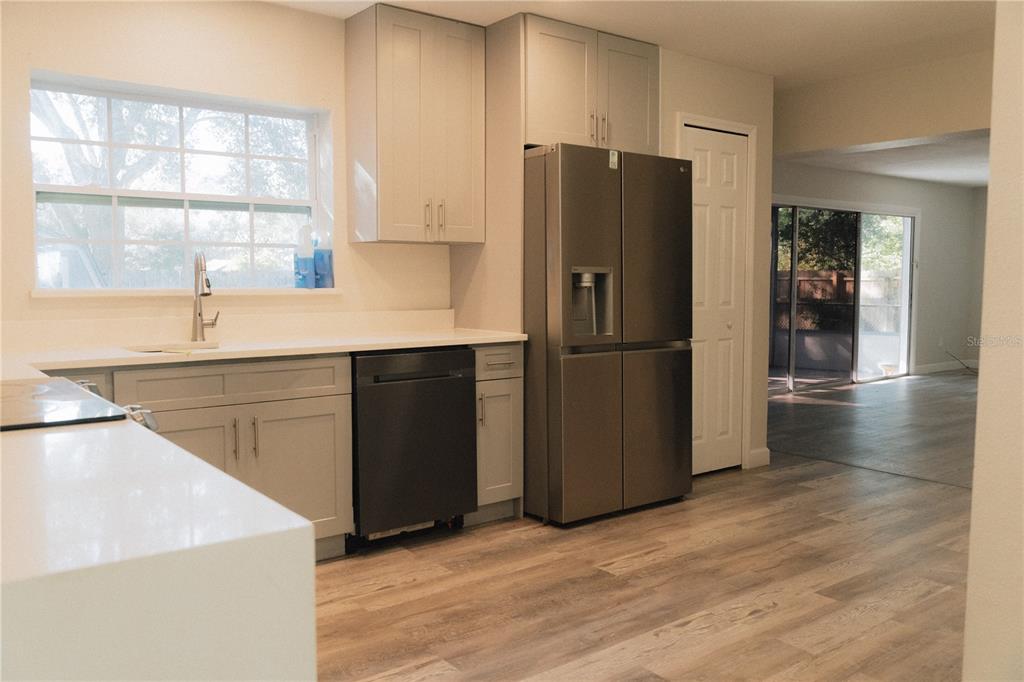 A kitchen features light gray cabinets, stainless steel appliances, and white countertops — 503 APRICOT DRIVE, OCOEE, FL