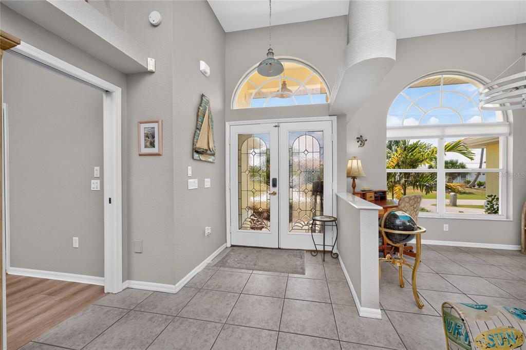 An entryway with tile flooring, a double glass door, and a half-wall desk area — 3015 WISTERIA PLACE, PUNTA GORDA, FL