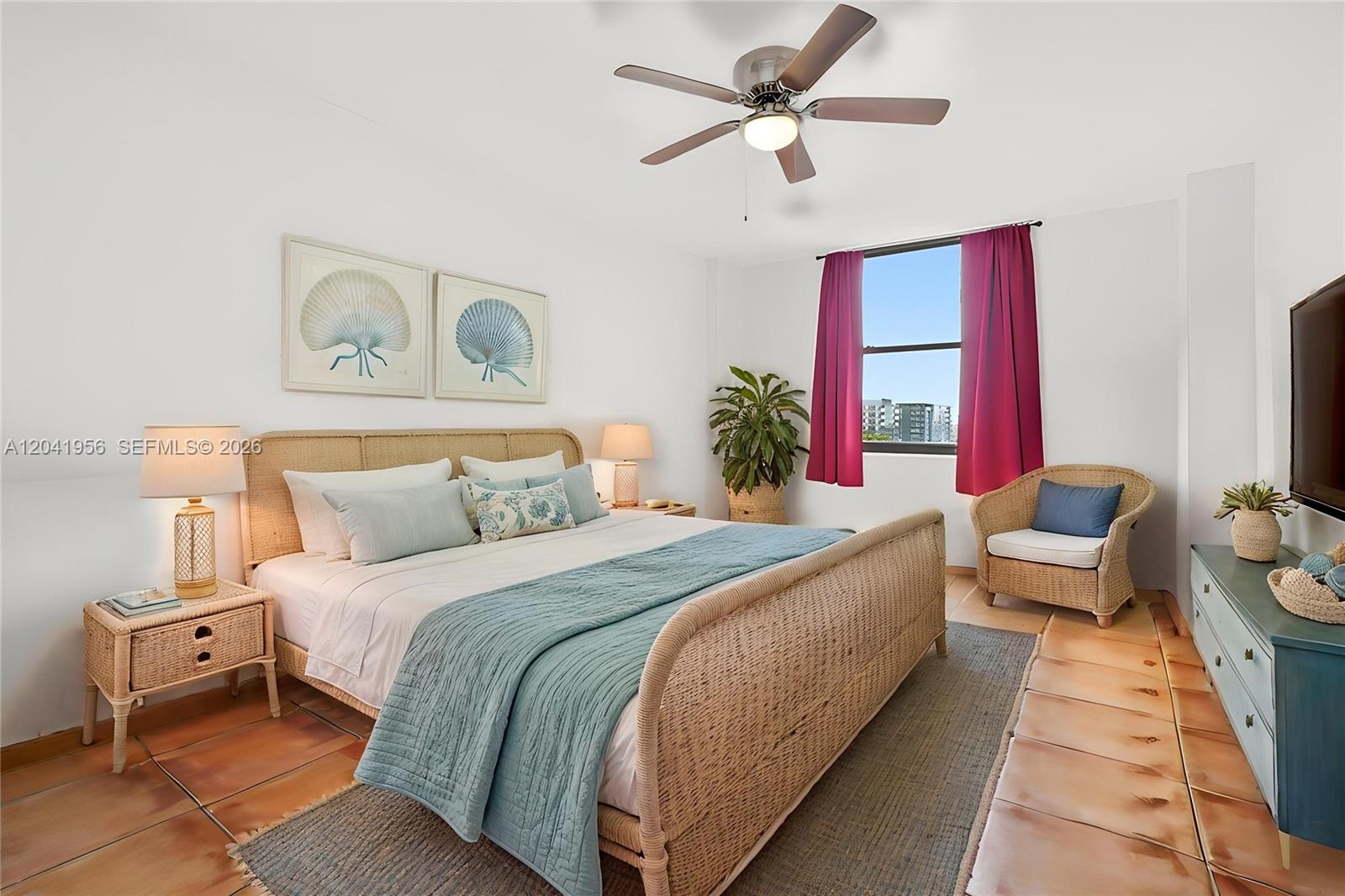 A bedroom features a wicker bed frame, a teal quilt, and a window with curtains — 1470 NE 123rd St # A609, North Miami FL 33161, NORTH MIAMI, FL