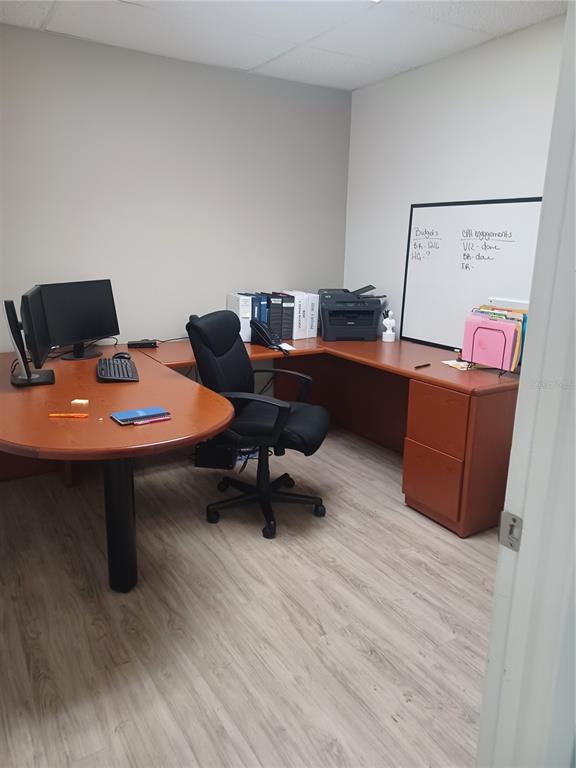 A conference room features a dark wood table, several black office chairs, and light flooring — 1310 N MAIN STREET, KISSIMMEE, FL