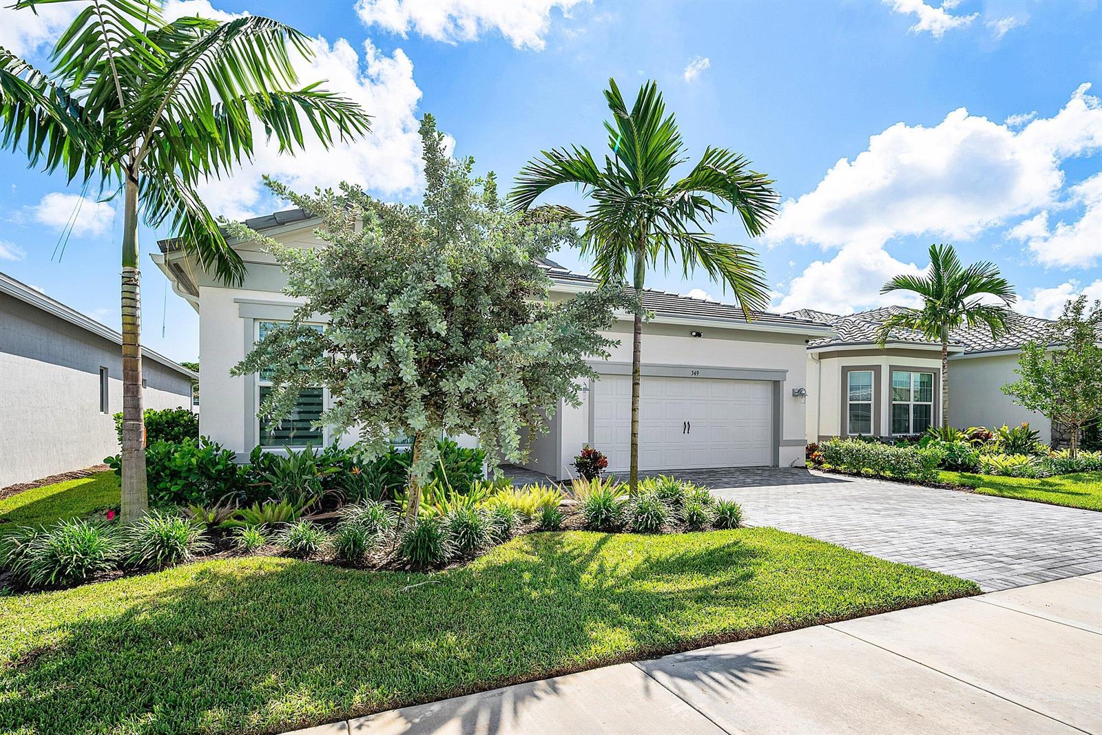 A single-story house with a paved driveway, palm trees, and landscaping under a blue sky — 349 Geillis Path, Delray Beach FL 33445, DELRAY BEACH, FL