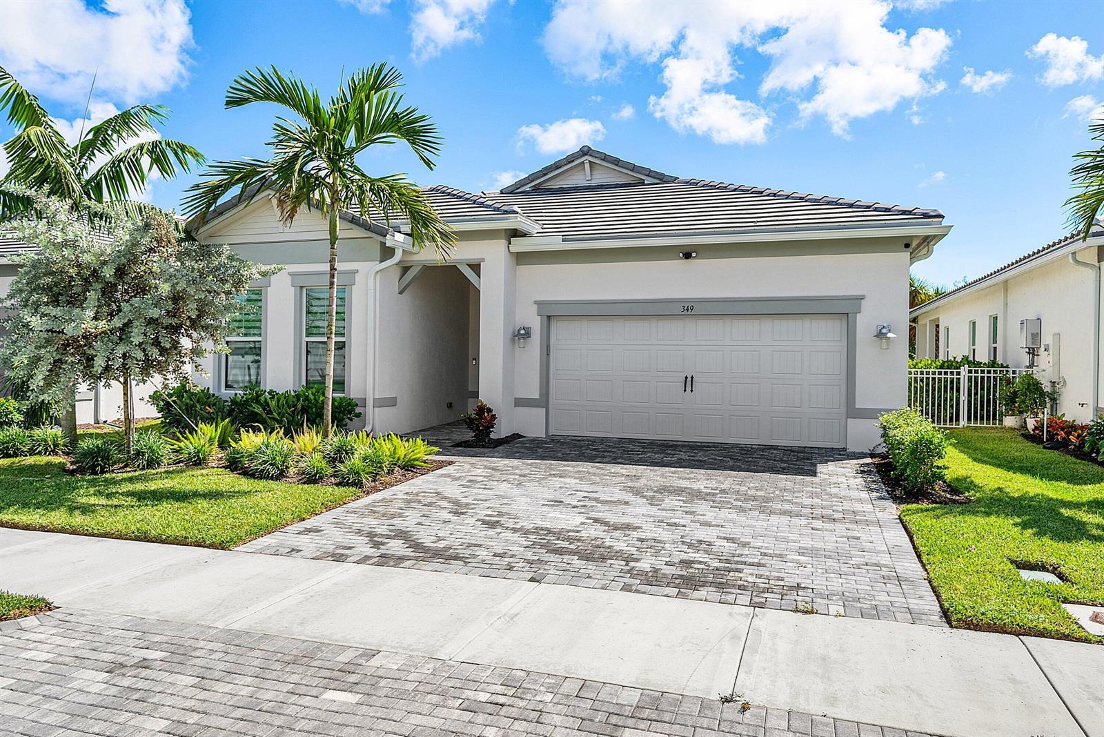 A single-story house with a paved driveway, a two-car garage, and a palm tree — 349 Geillis Path, Delray Beach FL 33445, DELRAY BEACH, FL