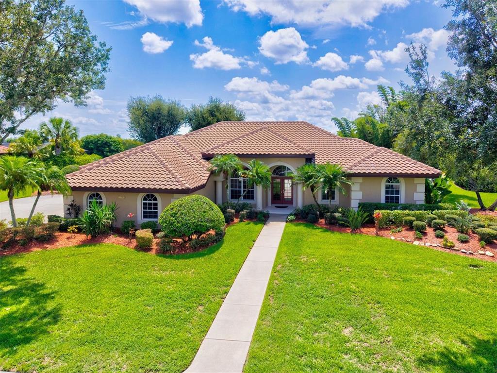 A single-story house with a tile roof, arched windows, and a front walkway — 7373 S SERENOA DRIVE, SARASOTA, FL
