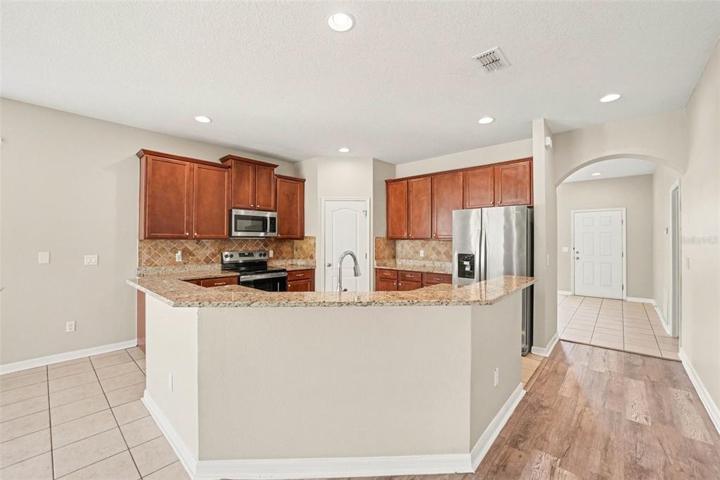 A kitchen with wood cabinets, granite countertops, a breakfast bar, and stainless steel appliances — 2727 EAGLE CLIFF DRIVE, KISSIMMEE, FL