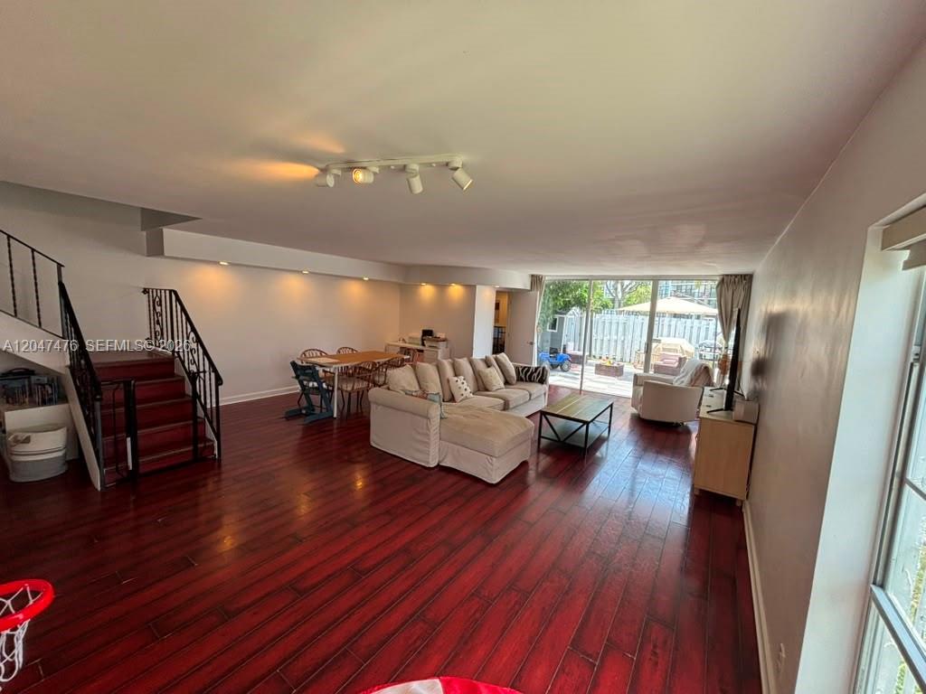 A living room with dark wood floors, a sectional sofa, and a staircase — 926 NE 27th Ave # 926, Hallandale Beach FL 33009, HALLANDALE BEACH, FL