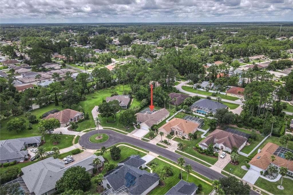 An aerial view of a suburban neighborhood featuring a house with a screened-in pool — 24 LAKESIDE PLACE W, PALM COAST, FL