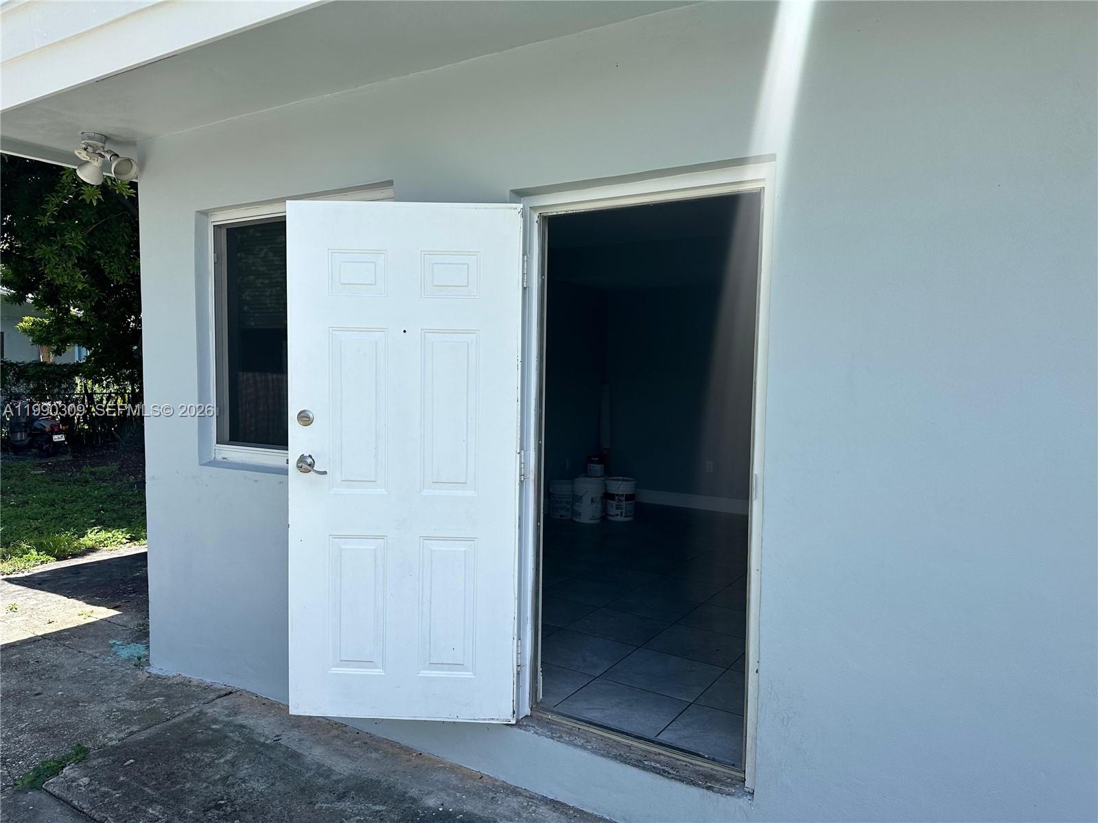 An open white door leads into a room with tiled floors and paint buckets — 6801 NW 2nd Ct # 6803, Miami FL 33150, MIAMI, FL