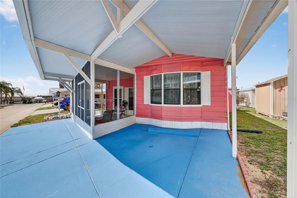 A bright pink mobile home features a blue painted driveway and a screened-in front porch — 251 PATTERSON ROAD UNIT D32, HAINES CITY, FL