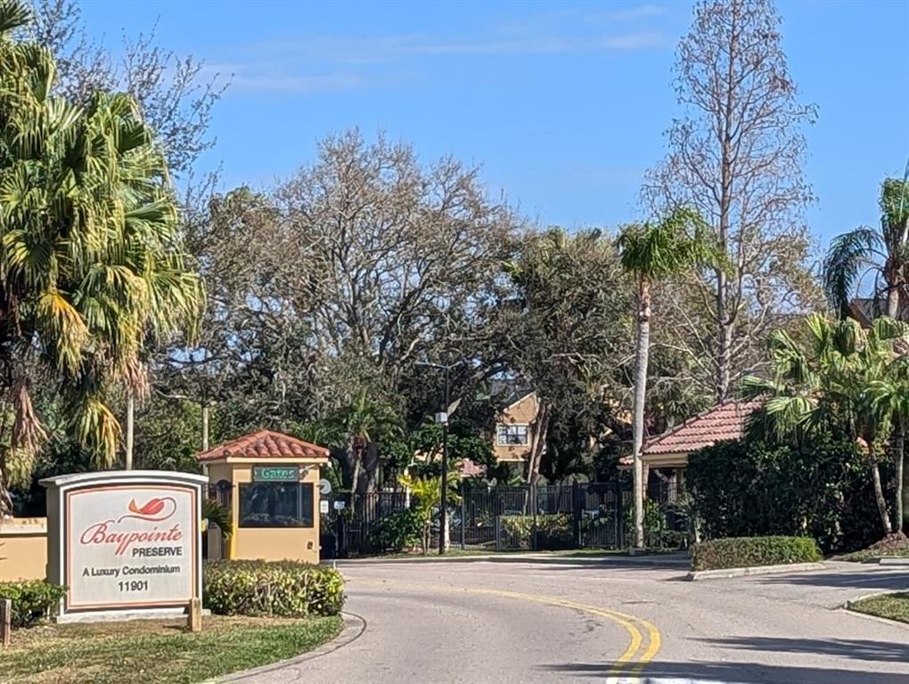 The entrance to a gated condominium community features a sign and a guard house — 11901 N 4TH STREET N UNIT 5212, ST PETERSBURG, FL