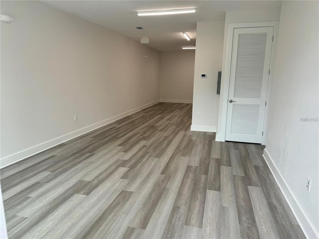 An empty room features light gray wood-look flooring, white walls, and a white louvered door — 419 MIKE ROBERTO WAY, OVIEDO, FL