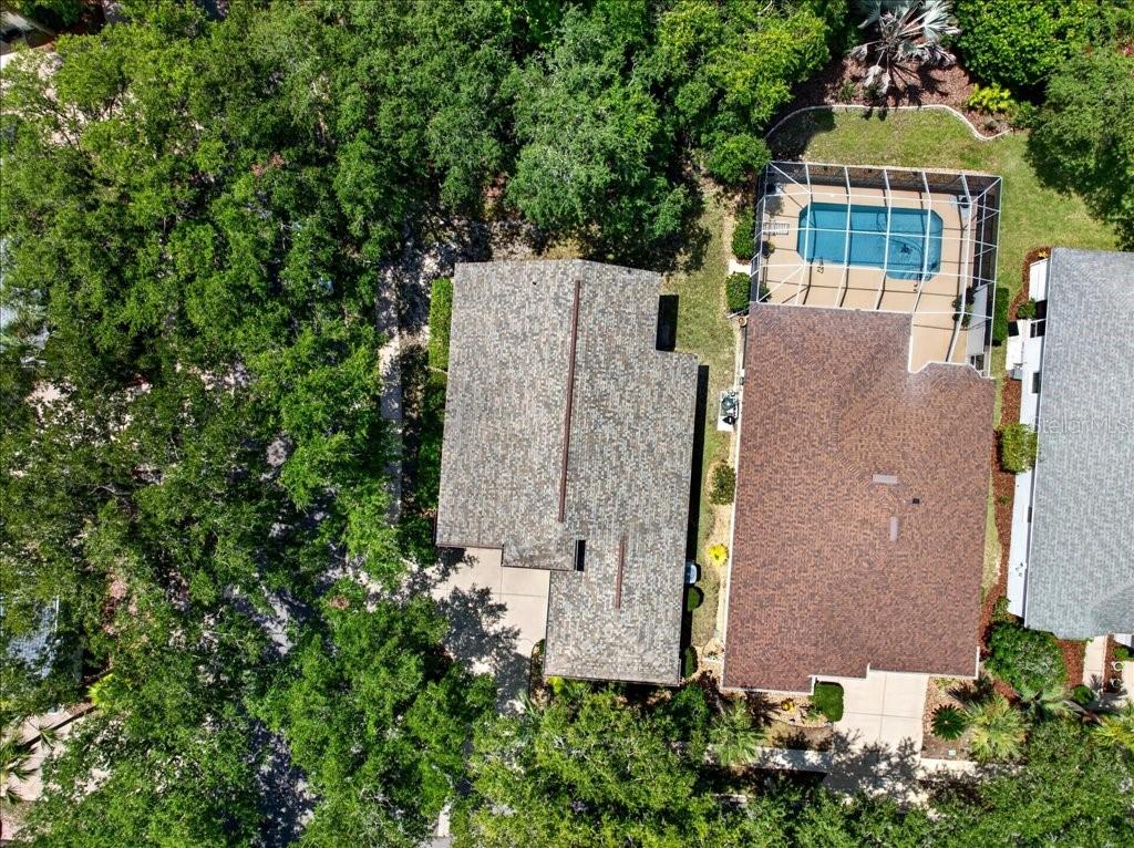 An aerial view shows two adjacent houses, one with a screened-in swimming pool — 1 GLENEAGLES PLACE, PALM COAST, FL