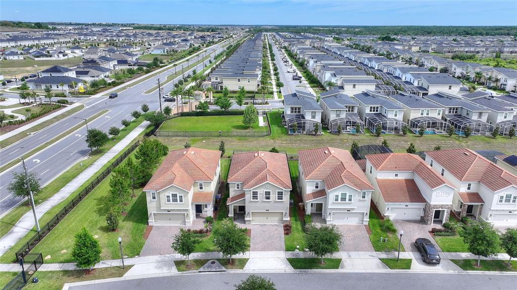 An aerial view shows a row of suburban houses with tile roofs and paved driveways — 8995 FLUFFY LIE COURT, DAVENPORT, FL