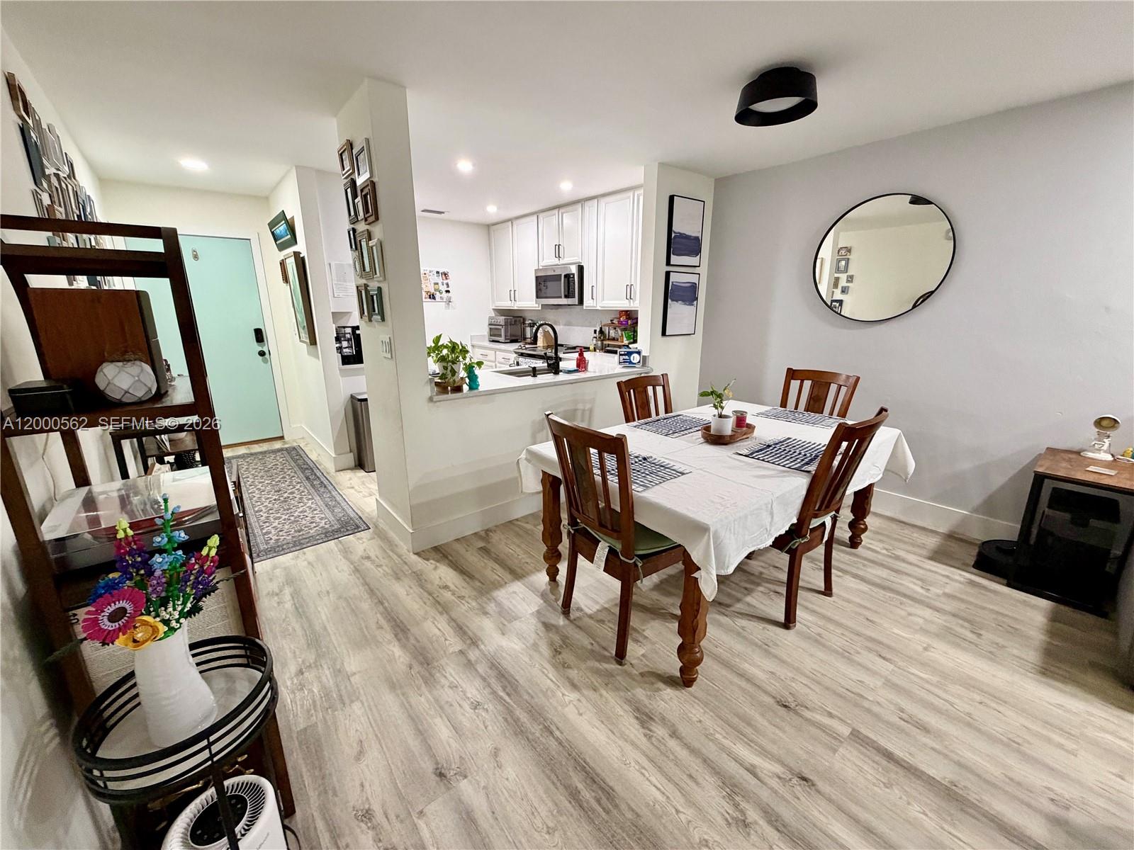 A dining area with a table and chairs sits adjacent to an open kitchen — 11259 SW 88th St # 204H, Miami FL 33176, MIAMI, FL