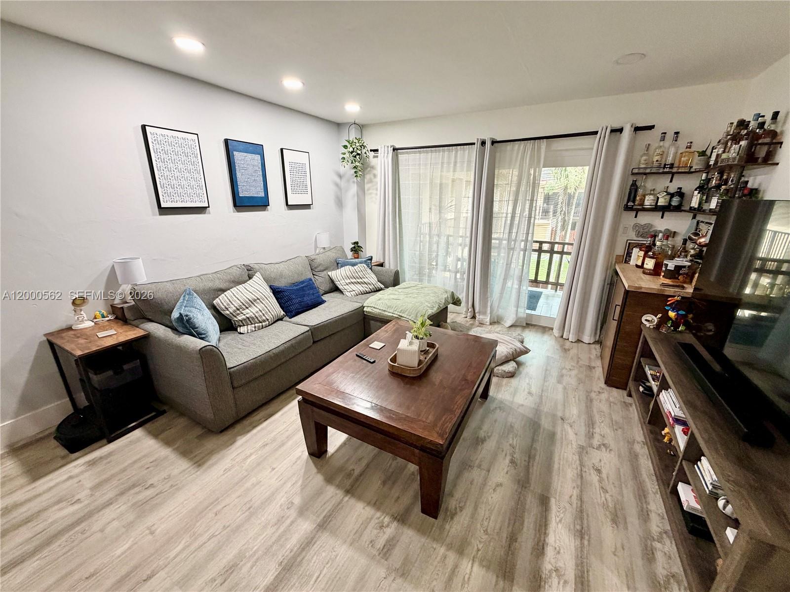 A living room features a gray sectional sofa, a wooden coffee table, and a bar area — 11259 SW 88th St # 204H, Miami FL 33176, MIAMI, FL