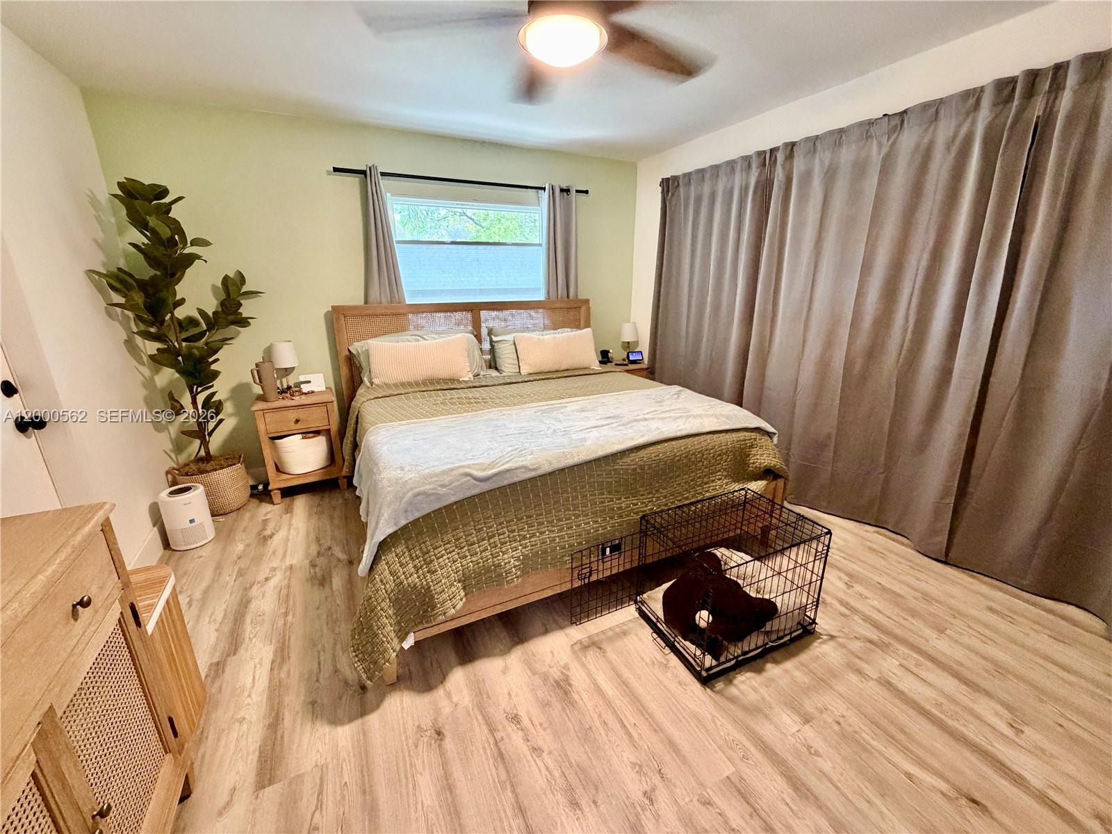 A bedroom features a bed with a rattan headboard, light wood flooring, and gray curtains — 11259 SW 88th St # 204H, Miami FL 33176, MIAMI, FL