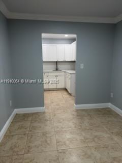 A view from a tiled room looking into a kitchen with white cabinets and countertops — 1805 W 56th St # 412, Hialeah FL 33012, HIALEAH, FL