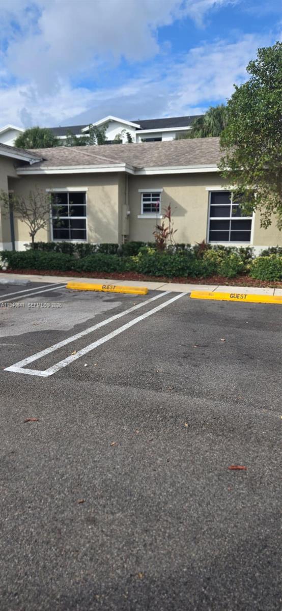 This exterior view shows a beige building with two guest parking spaces in the foreground — 484 NE 4th Ave, Florida City FL 33034, FLORIDA CITY, FL