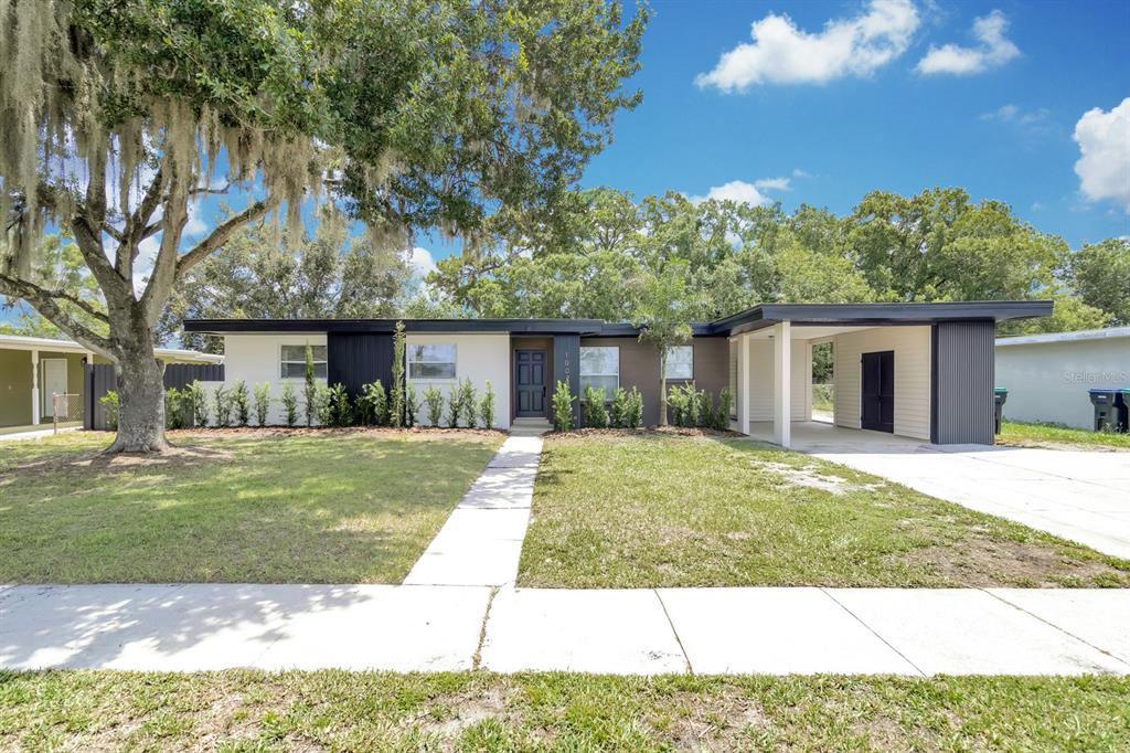 A single-story mid-century modern house with a flat roof, carport, and a front lawn — 1007 EGAN DRIVE, ORLANDO, FL