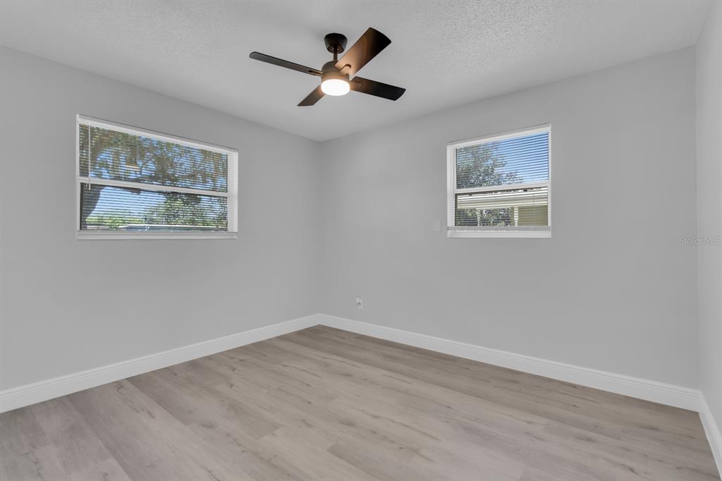 An empty bedroom with light gray walls, wood-look flooring, and a ceiling fan — 1007 EGAN DRIVE, ORLANDO, FL