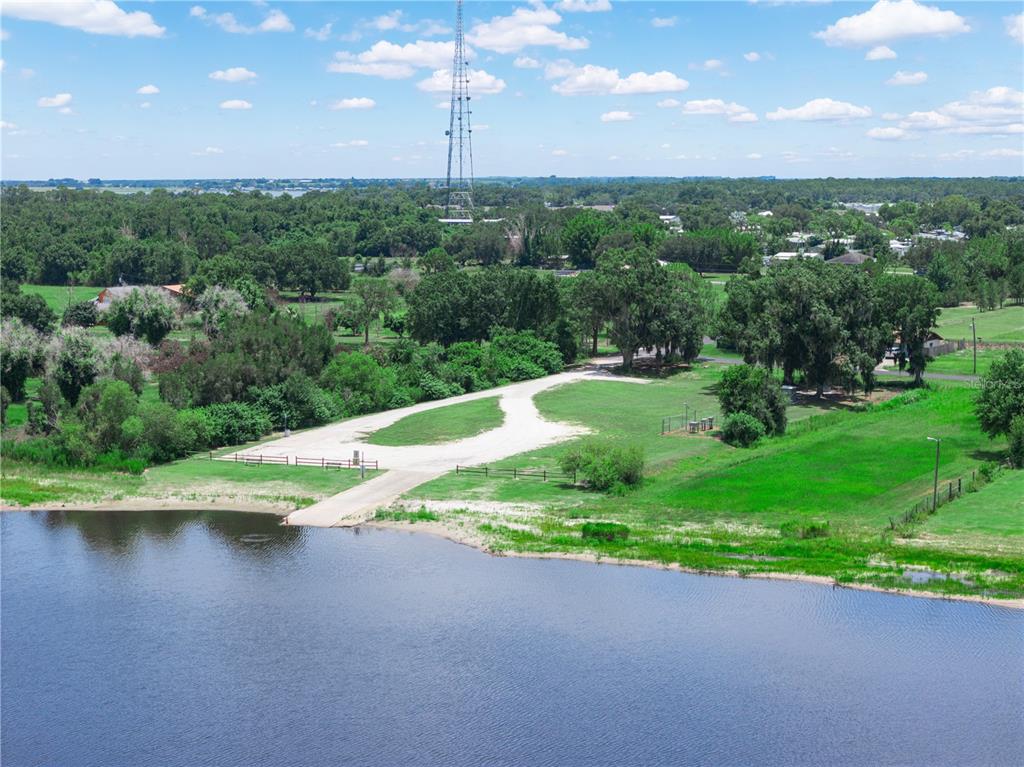 An aerial view shows a boat ramp leading into a lake near a grassy lot — 860 KEEN ROAD, FROSTPROOF, FL