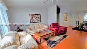 A living room features a beige sofa, a red armchair, and a wooden coffee table — 4555 Pioneer 16th St, Clewiston FL 33440, CLEWISTON, FL