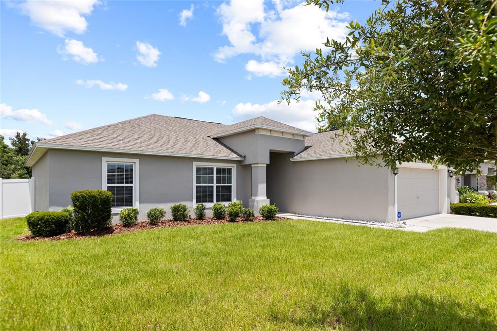 A single-story gray house with a two-car garage and a front lawn — 4582 PENKERT PLACE, LAKELAND, FL