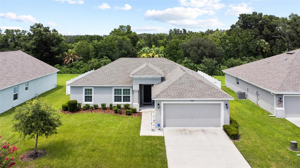 An aerial view shows a single-story suburban house with a gray roof and garage — 4582 PENKERT PLACE, LAKELAND, FL