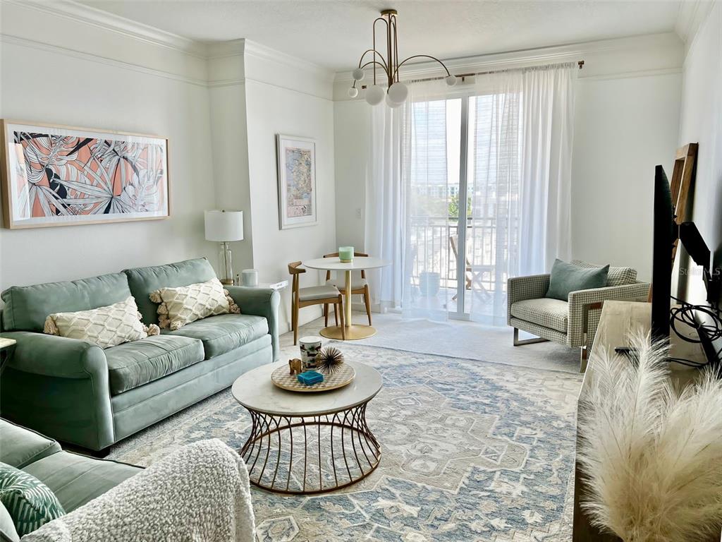 A living room features a green sofa, a round coffee table, and a small dining area — 750 N TAMIAMI TRAIL UNIT 708, SARASOTA, FL