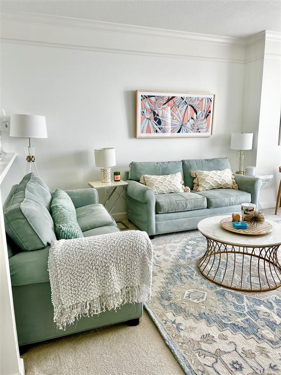 A living room features two light green sofas, a marble coffee table, and patterned rug — 750 N TAMIAMI TRAIL UNIT 708, SARASOTA, FL