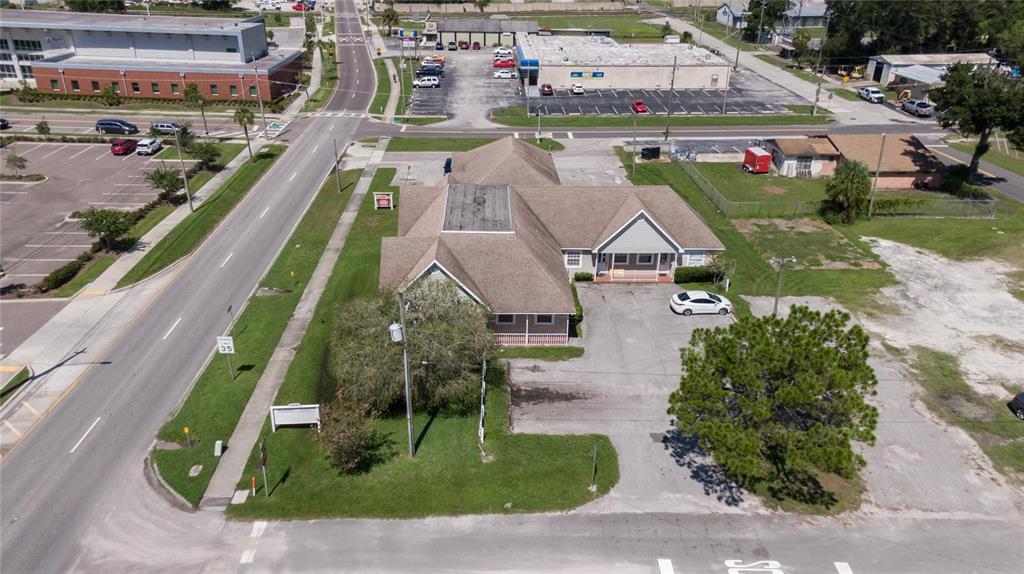 An aerial view shows a commercial building with a parking lot and surrounding streets — 504 E BAKER STREET, PLANT CITY, FL