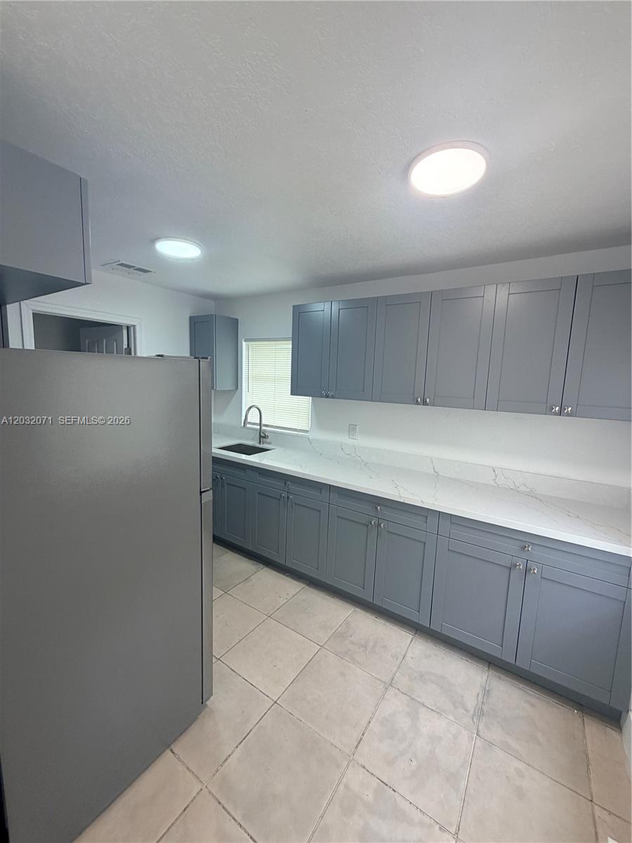 A kitchen features grey shaker-style cabinets, white marble-patterned countertops, and light-colored tile flooring — 753 SW 3rd Pl # 753, Dania Beach FL 33004, DANIA BEACH, FL